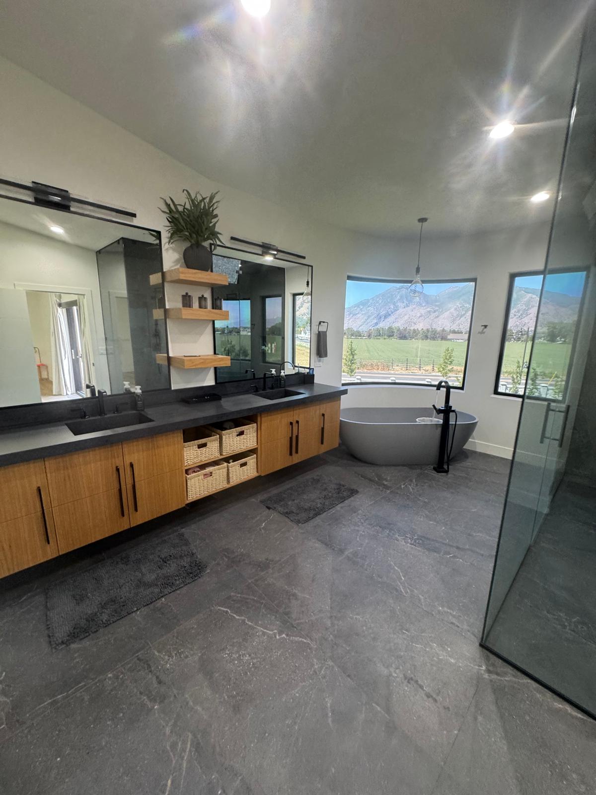 Luxury bathroom with freestanding tub, glass shower and mountain views completed by GOAT TILE