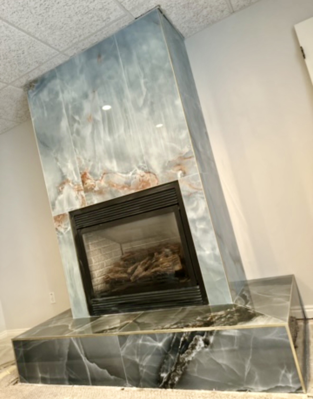 Fireplace and raised hearth clad in polished large-format tile