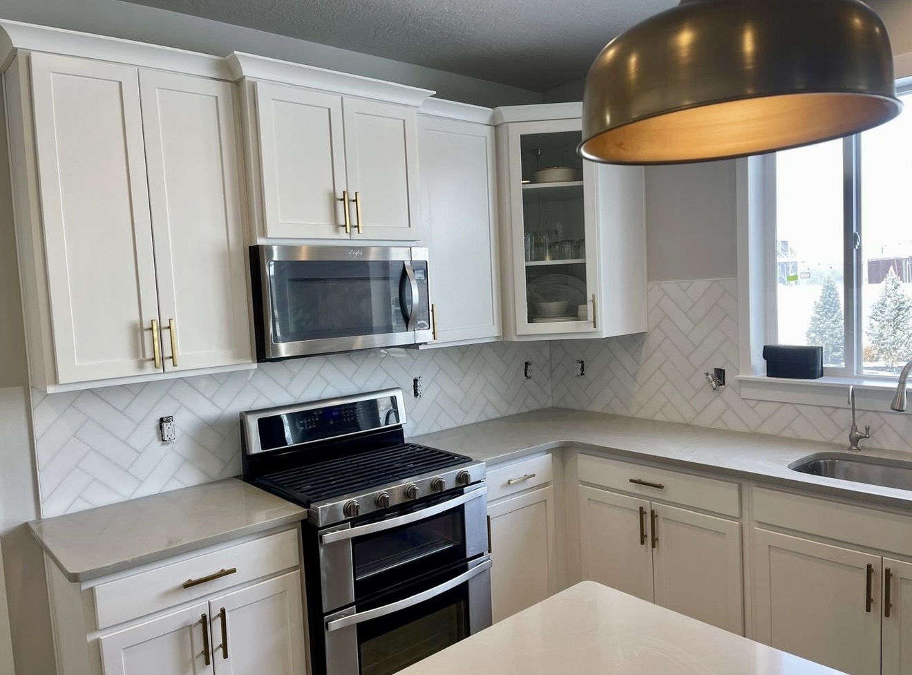White kitchen with herringbone tile backsplash